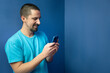 © deliris - Happy young man with mobile phone on color background. High quality photo