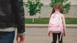 © Mariia - Father with cute little daughter see off to school elementary class outdoor near school building. Child pupil with backpack going dad with love before going classroom