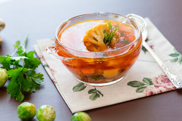 Wall Mural - vegetable soup with Brussels sprouts and cauliflower, in a glass plate on a wooden table