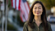 ©  Studio AB Images - Attractive adult asian american woman portrait in front of flag of USA.