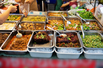 A table full of food with a The thai food is in many different dishes and is served in a buffet style