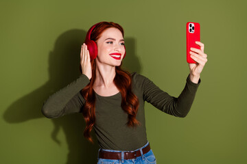 Wall Mural - Photo of shiny attractive lady dressed shirt earphones recordign video modern gadget empty space isolated green color background