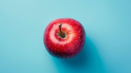 Wall Mural - Red apple on solid blue background, commercial photography style