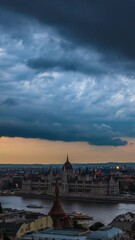 Wall Mural - Thunderclouds on the Budapest Parliament whose lights are lit in the dark vertical video