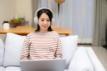 Wall Mural - Woman study on laptop computer with her headphone