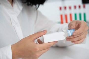 Poster - a girl medical worker takes out a medicine from a white cardboard package