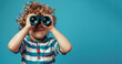 © Dmitriy - happy boy with Binoculars in striped clothes on blue background, banner, copy space