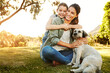 © peopleimages.com - Park, mother and girl with dog, smile and sunshine with weekend break, happiness and nature. Family, single parent and mama with daughter, animal and pet with fun, playing and countryside with summer