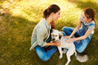 © peopleimages.com - Mom, girl and dog in park to relax with bonding, love and above on holiday with care for animal. Family pet, mother and daughter with smile, connection or play outdoor on lawn in garden on vacation