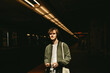 © ADDICTIVE STOCK - Young man waiting on a subway platform with dramatic lighting