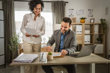 Wall Mural - Adult man sign insurance or contract to his woman colleague at office