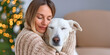 © Barry - Blonde woman, hugging her white dog on the sofa, with heads touching and eyes closed.