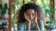 © Neat Design Studio - Portrait of a young sad stressed woman feeling overwhelmed and suffering from a headache while sitting in front of her laptop in her home