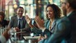 © sirisakboakaew - Businesswoman high fives male colleague in meeting Professional businessman high-fives during meeting in conference room