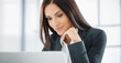 © Barry - Young woman with dark hair in business suit, working on laptop computer in a brightly lit office. close up, shallow depth of field.