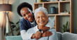 © peopleimages.com - Senior, woman and caregiver with hug in nursing home for healthcare support, medical help and happy on sofa. Elderly person, nurse and embrace with smile for kindness or relax in retirement homecare