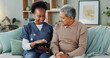 © peopleimages.com - Tablet, healthcare and black nurse in home by senior man, internet and communication on wellness on sofa. African caregiver, elderly person and technology for learning and help in chronic illness