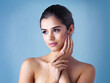 © peopleimages.com - Beauty, thinking and woman in studio with natural skincare, confident makeup and luxury cosmetics. Dermatology, facial care and girl with wellness, relax and healthy skin glow on blue background.
