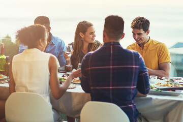 Wall Mural - Friends, wine and patio party with food, celebration and alcohol together with glass and young people on rooftop. Event, drinks and eating on a holiday at table with group meal and balcony at sunset