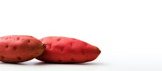 Poster - Copy space image of a vibrant red sweet potato against a white backdrop