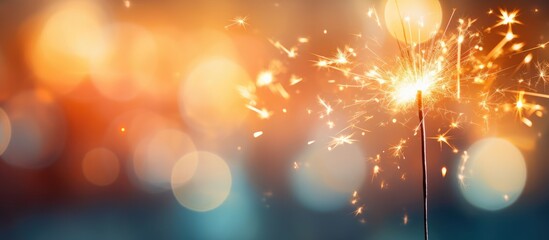 Poster - blurred bokeh light background with a sparkler in the foreground creating a captivating copy space i