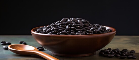 Poster - A copy space image of black beans in a ceramic bowl with a plastic spoon resting on a dark marble surface