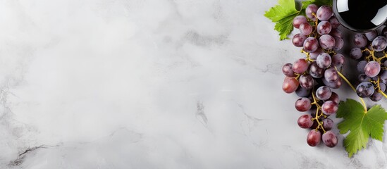 Fototapete - A top view of wine and grapes on a grey marble background with ample copy space for additional elements or text