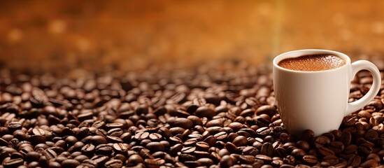 Wall Mural - A coffee mug placed on a coffee bean textured background with copy space image