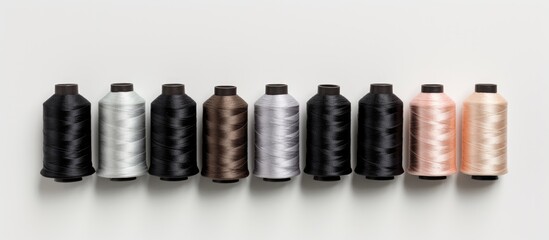 Poster - A close up top view of a set of sewing threads on a white background displaying a gradient of gray colors Ample copy space image