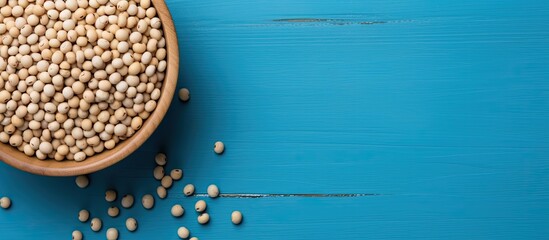Poster - A top down view of a bowl containing soy beans on a blue table with plenty of space for additional images