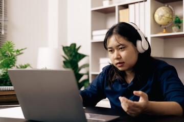 Happy student, studying for MBA exam, takes advantage of distance learning to attend school from home, balancing training and class. Woman studies book and research for online academy using laptop.