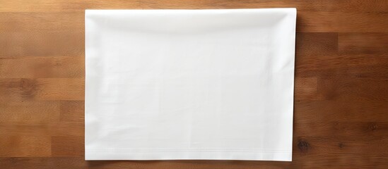 Poster - A minimalistic top down perspective of a white kitchen napkin placed on a table with no objects nearby The napkin is neatly folded creating ample blank space for customization