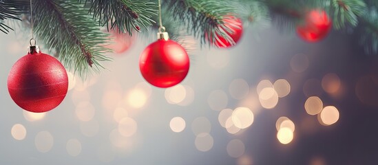 Close up image of fir tree branches adorned with red new year balls against a stunning backdrop of colorful bokeh Depicts a Christmas composition suitable for a greeting card Ample copy space availabl