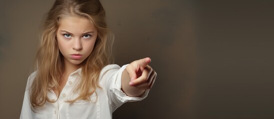 Aufkleber - Isolated image of a youthful girl confidently pointing her finger towards the copy space