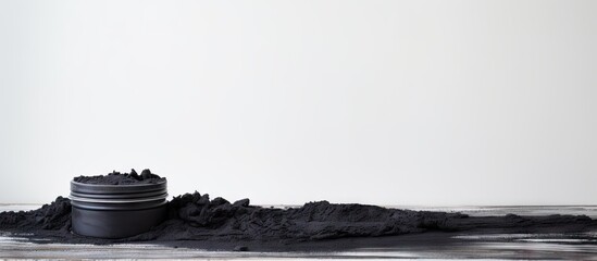 Poster - A copy space image of black cosmetic mud placed on a white wooden table