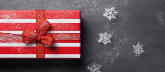 Poster - A handmade box with red striped paper adorned with fir and snow represents the concept of Christmas and New Year Seen from above on a grey background there is ample copy space in the image