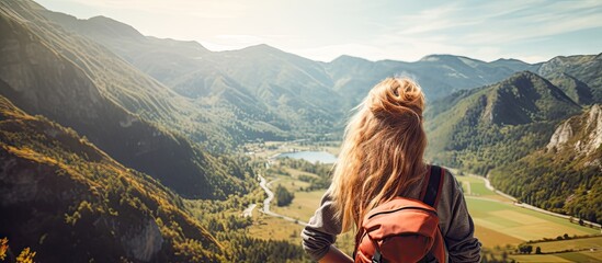Poster - Copy space image of a cheerful teenage girl with a backpack experiencing joy while gazing at the scenic mountain view This background represents the concept of a summer vacation hike