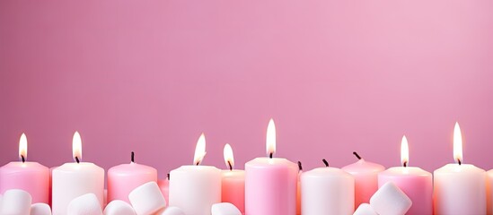 Poster - The pink pastel candles and marshmallows are arranged in a top view on a pink pastel background creating a captivating copy space image
