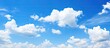 A bright and sunny day with clear blue skies scattered clouds and ample copy space image