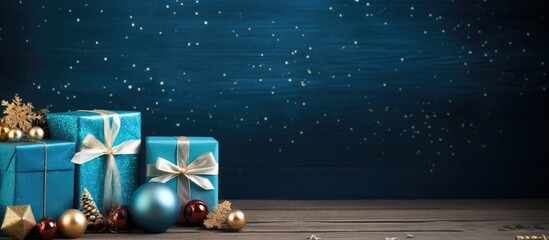 Poster - A blue wooden background with a festive touch of Christmas gifts and decorations Copy space image
