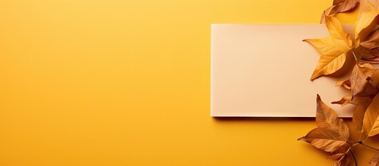 Poster - Autumn foliage frames a blank calendar sheet setting the scene against a yellow textile backdrop in this copy space image