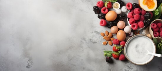 Poster - A healthy breakfast concept featuring organic ingredients such as berries milk eggs and oatmeal The image showcases these items on a grey concrete background with copy space available It serves as a b