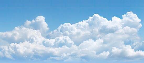 Aufkleber - A nature background featuring puffy white clouds against a clear blue sky with copy space image available