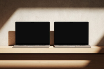 Wall Mural - two apple macbooks pro on the wooden desk on a plaster background