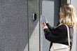 © Angelov - female entering secret key code for getting access and passing building using application on mobile phone, woman pressing buttons on control panel for disarming smart home system