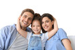 © ty - Positive friendly young parents with smiling little daughter sitting on sofa together while relaxing on a transparent background