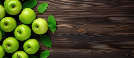 Poster - A captivating top down view of a wooden background featuring an arrangement of crisp green apples and ample free space for text