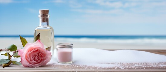 Poster - A table displaying a bottle of rose essential oil alongside sea salt with plenty of copy space for an image