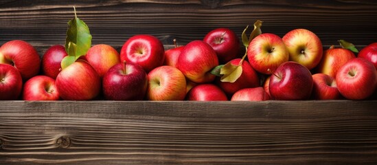 Poster - A box filled with ripe apples sits on a rustic wooden background providing ample copy space