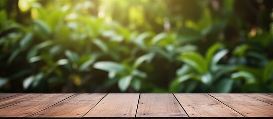Poster - A wooden table on a deck with a background of blurred foliage creates a copy space image